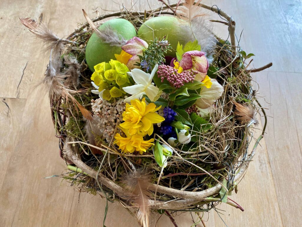Osternest mit frischen Blumen